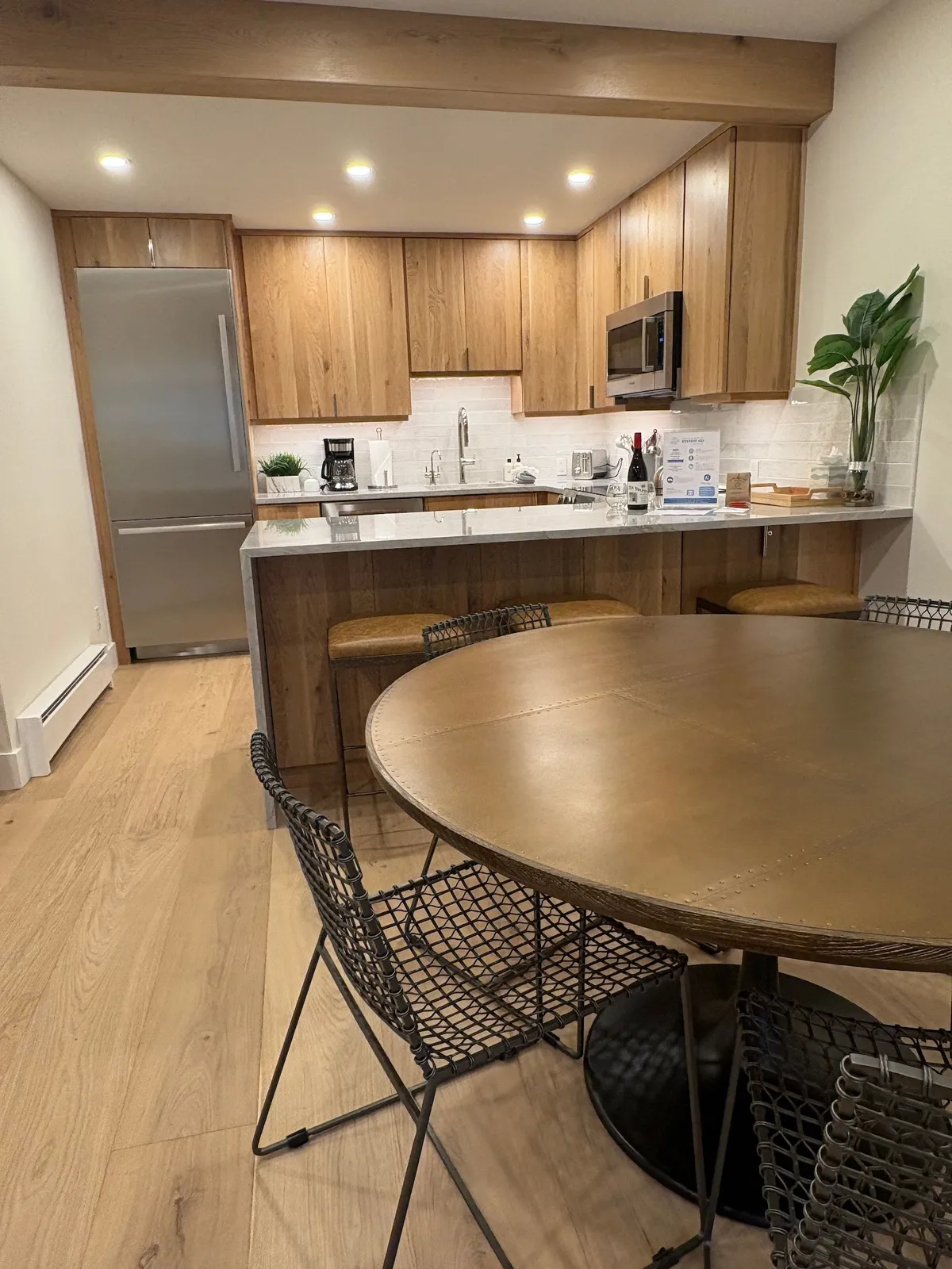 This image showcases a modern kitchen island, sleek dining table, and contemporary appliances in a bright, social setting. The arrangement speaks to culinary creativity and communal dining, with space for friends and family to gather comfortably.